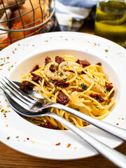 Pasta with parmesan and vegetables on wooden table
