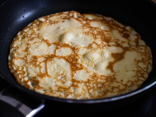 Sweet crepes frying in pan
