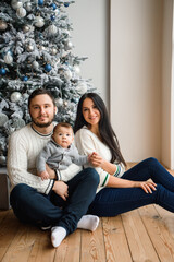 Young family near festive Christmas tree