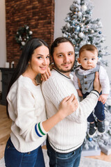 Young family near festive Christmas tree