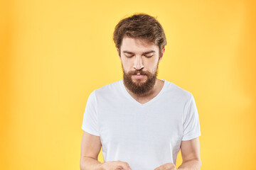 emotional bearded man in t-shirt cropped view yellow background studio