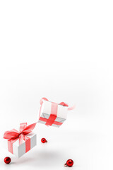 Xmas background red. White gift box with red ribbon, New Year balls in Christmas composition on white background for greeting card. Xmas backdrop with space for text.