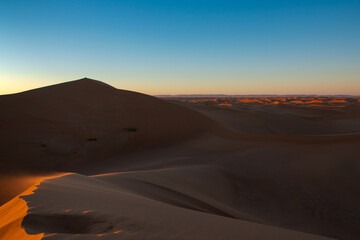 Fototapeta na wymiar Huge desert dunes of Erg Chigaga, at the gates of the Sahara, al amanecer. Morocco. Concept of travel and adventure.