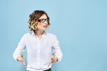 Business woman in a light shirt on a blue background gestures with her hands emotions model work