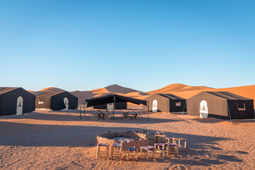 Desert camp and campfire in dunes of Erg Chigaga, at the gates of the Sahara. Morocco. Concept of...