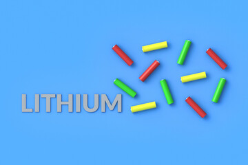 Many blank green red and yellow color batteries aa or aaa size near word lithium scattered on blue background. Top view. 3d rendering