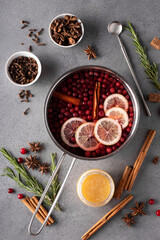 hot cranberry drink with lemon honey and spices in a gray saucepan