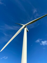 Fototapeta premium Wind farm turbines that produce electricity energy. Windmill Wind power technology productions Wind turbines standing in green field - stock footage