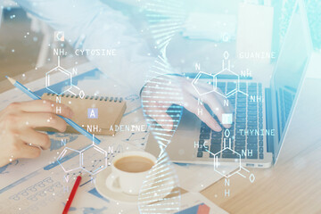 DNA hologram with businessman working on computer on background. Concept of bioengineering. Double...