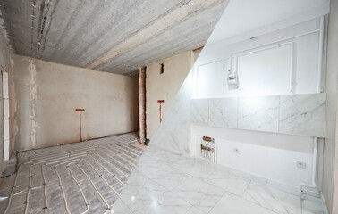 Light spacious new room in apartment before and after repairs. Empty walls, floor heating pipe...