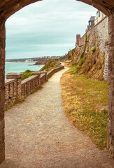 walking path, trail through arched stone door on a beach