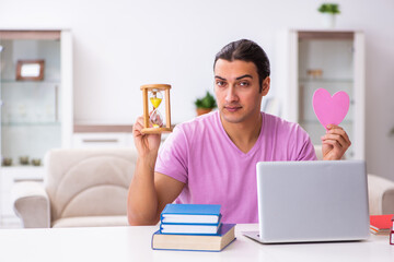 Male student in love preparing for exams in time management conc