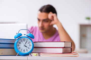Male student in love preparing for exams in time management conc