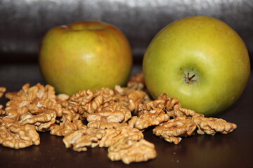 Large green apples and walnuts on a dark background