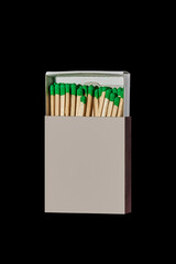Box with green matches isolated on a black background