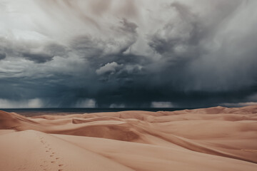 A thunderstorm rolling in over the giant desert sand dunes of Great Sand Dunes National Park in...