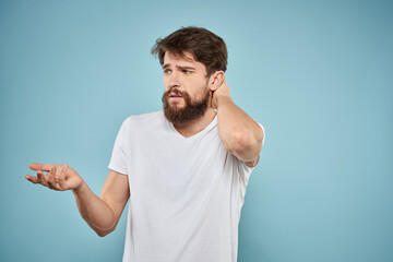 Fototapeta premium Man in white t-shirt lifestyle studio emotions facial expression blue isolated background