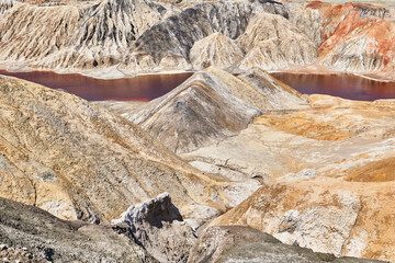 deserted area with a red lake in the place of an old clay quarry