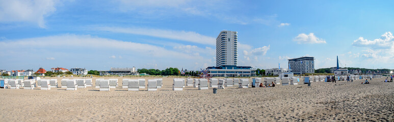 Beach of Warnemuende with hotels and rows of white beach chairs