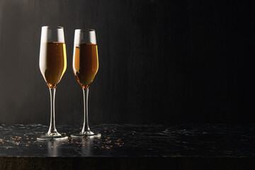 Two glasses of champagne, wine on a black background, a place for text on the right, copypace. New year and Christmas background