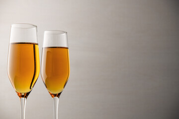 Two glasses of champagne, wine on a gray background, a place for text on the right, copypace. New year and Christmas background