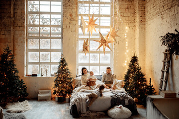 Happy family with little children near the Christmas tree at home, caring father with loving mother spend winter holidays with kids, smiling, new year celebration concept
