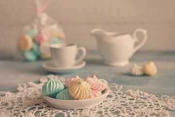 Meringues of a delicate pastel color are on the table for morning tea