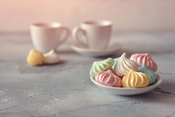 Meringues of a delicate pastel color are on the table for morning tea