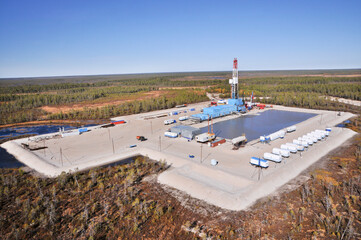 Fototapeta premium Oil rig in swampy and wooded area. There are clean lakes around. Oil production (top view)