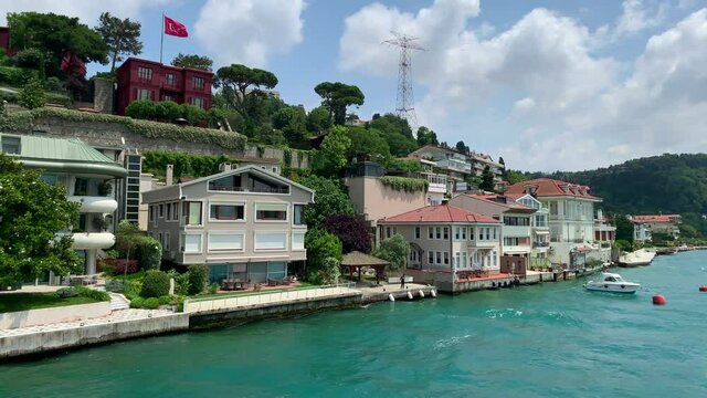 Footage of luxury houses in upscale neighborhood called "Kandilli" by Bosphorus in Istanbul. It is a beautiful summer scene on cloudy summer day. Camera moves forward.