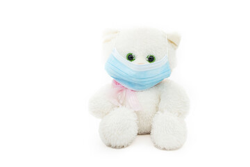 Concept of COVID-19 outbreak protection with medical mask. Toy bear using medical mask as prevention measure for coronavirus on white background