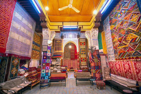 FES, MOROCCO - NOVEMBER 20, 2019: Interior of Carpet shop with colourful moroccan rugs and berber carpets on display in a souk market in the centre of medina. Fes El Bali (Maze of Fez)