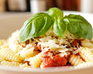 Pasta with tomato sauce Parmesan and basil close up 