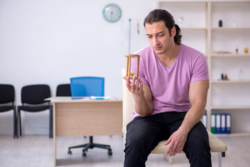 Young male patient waiting for doctor in time management concept