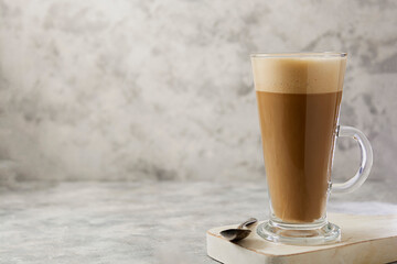 Coffee drink with whipped milk in tall glass cup with cinnamon. Copy space.