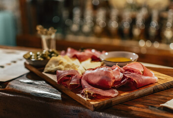 Charcuterie board with cured pork meat, sauce, bread and olive