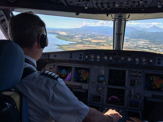Fototapeta premium avion en phase d'atterrissage vu depuis le cockpit avec un pilote et vue sur la côte 