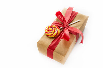 Christmas gift wrapped in craft paper and lollipop are on a white background. New Year and Christmas concept