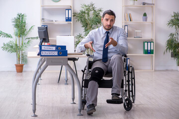 Young leg injured employee working in the office