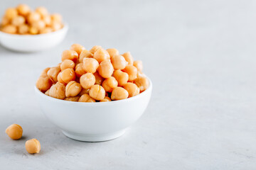 Cooked Chickpeas in white bowl on gray stone background
