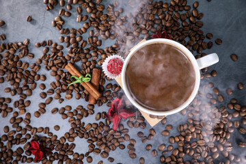 White cup full of coffee beans close up against the dark grey background. Coffee mug. Morning espresso.	