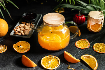 Fruit hot tea with the addition of oranges, lemons, mandarins and raspberries in a glass cups on a table. Healthy hot drink. tea with fruit and berries in a glass teapot. tea for colds.