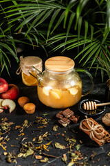 Fruit hot tea with the addition of oranges, lemons, mandarins and raspberries in a glass cups on a table. Healthy hot drink. tea with fruit and berries in a glass teapot. tea for colds.