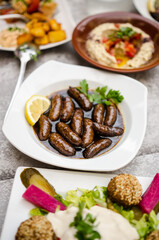 Makanek (Lebanese Sausages) served in a hot pomegranate molasses with lemon and parsley