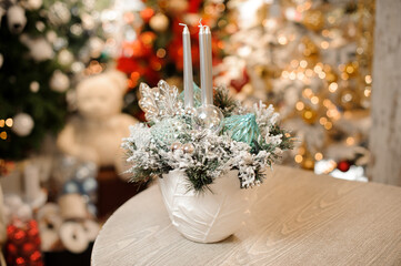 beautiful composition in pot with candles inside decorated with fir branches and tree toys