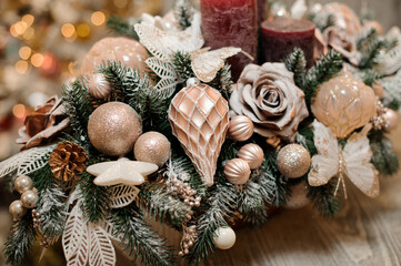 close-up of beautiful spruce branch decorated with rose and different golden christmas tree toys