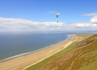 Paragliding above Rhossili Beach in Wales	