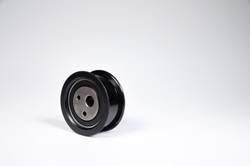 New timing belt tensioner roller close-up macro shot on gray background