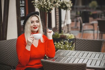 Woman at European cafe, plus size blonde nice woman . Pretty nice girl in restaurant at terrace with a cup of coffee, lifestyle ladies, tourist at Europe 