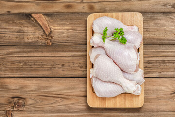 Raw chicken legs on wooden background. Top view, flat lay, space for text.